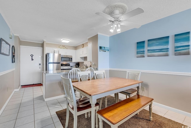 dining space with crown molding, ceiling fan, a textured ceiling, and light tile floors