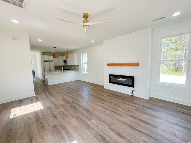 unfurnished living room featuring baseboards, a fireplace, and visible vents