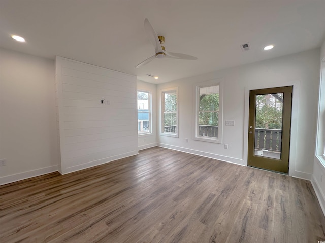 empty room with baseboards, visible vents, dark wood-type flooring, and recessed lighting