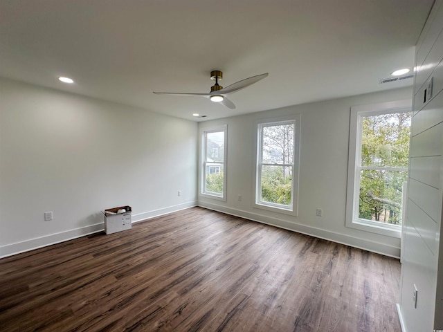 spare room featuring dark wood-type flooring, baseboards, and ceiling fan