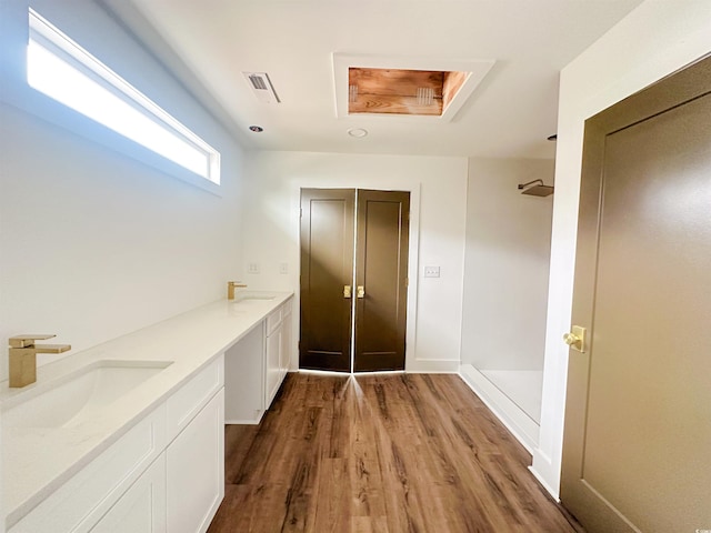 full bath featuring walk in shower, a sink, and wood finished floors