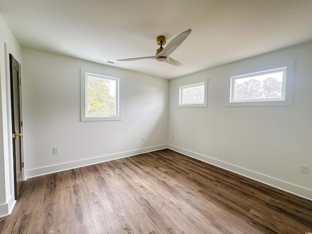 spare room featuring a ceiling fan, visible vents, light wood-style flooring, and baseboards