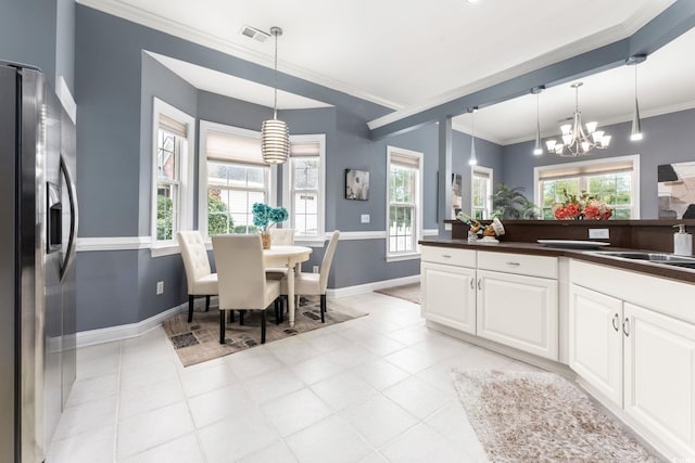 kitchen featuring a healthy amount of sunlight, pendant lighting, and stainless steel fridge with ice dispenser