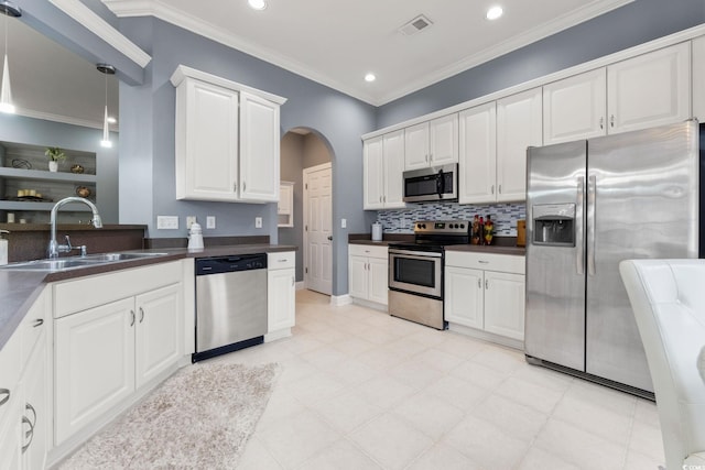 kitchen featuring sink, hanging light fixtures, stainless steel appliances, white cabinets, and ornamental molding