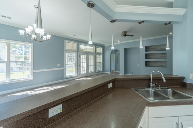 kitchen featuring ornamental molding, white cabinets, sink, and ceiling fan with notable chandelier