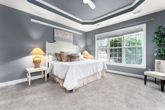 bedroom featuring a raised ceiling, crown molding, carpet, and ceiling fan