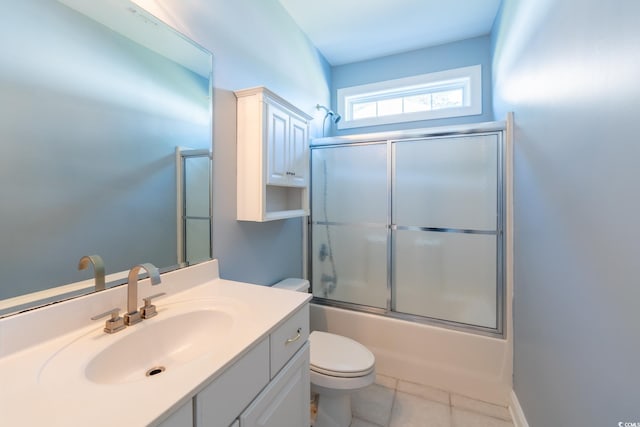 full bathroom featuring vanity, toilet, combined bath / shower with glass door, and tile patterned flooring