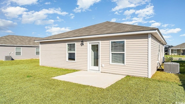 rear view of property featuring central AC unit, a patio, and a lawn