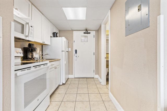 kitchen featuring a paneled ceiling, white appliances, light tile patterned floors, white cabinets, and electric panel