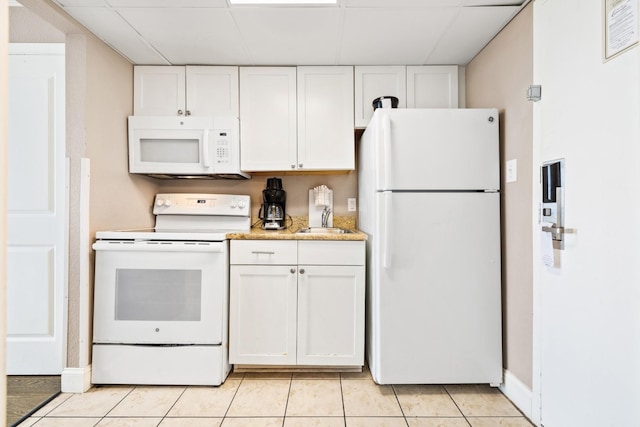 kitchen with white cabinetry, light tile patterned flooring, white appliances, and light stone counters