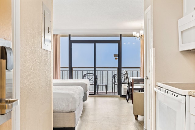 bedroom with floor to ceiling windows, electric panel, multiple windows, and a notable chandelier