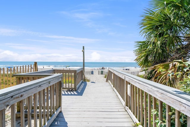 view of property's community featuring a water view and a beach view