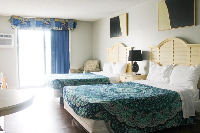 1207 S Ocean Blvd Unit 50606, Myrtle Beach, SC 29577 - bedroom with a wall mounted AC, dark hardwood / wood-style floors, and a textured ceiling
