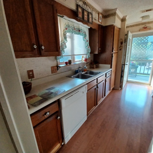 kitchen featuring dishwasher, sink, crown molding, light hardwood / wood-style floors, and decorative backsplash