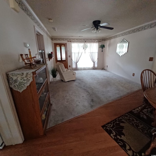 living area with wood-type flooring, a textured ceiling, and ceiling fan