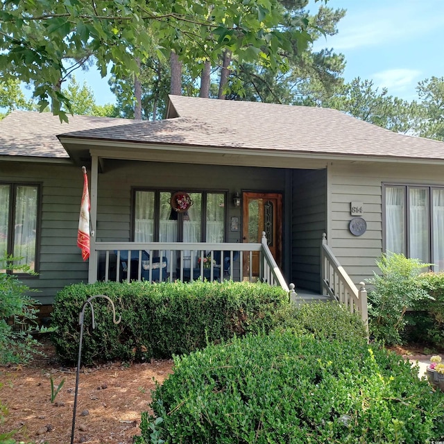 rear view of house featuring covered porch