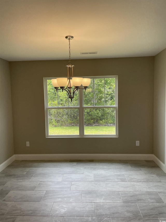 empty room featuring an inviting chandelier