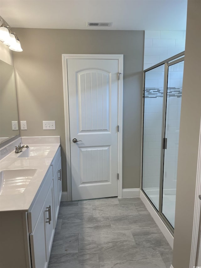 bathroom with vanity and a shower with shower door