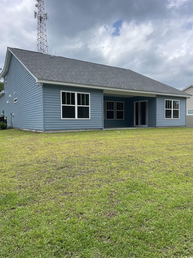 back of property featuring a lawn and cooling unit