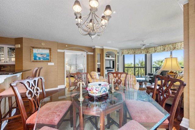 dining area featuring a textured ceiling, hardwood / wood-style flooring, and ceiling fan with notable chandelier