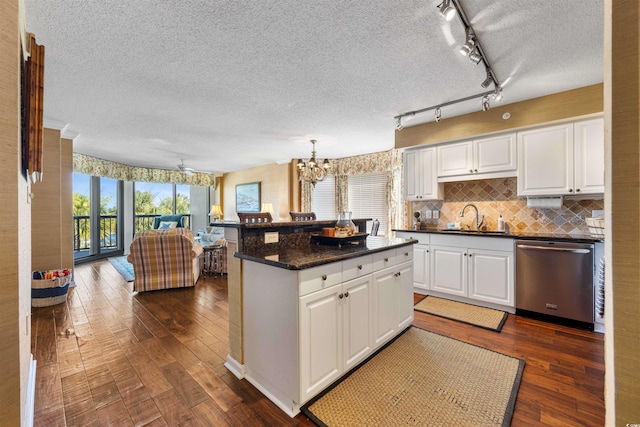 kitchen with white cabinets, tasteful backsplash, sink, track lighting, and dishwasher