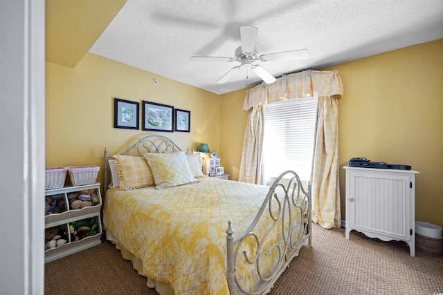 carpeted bedroom with ceiling fan and a textured ceiling