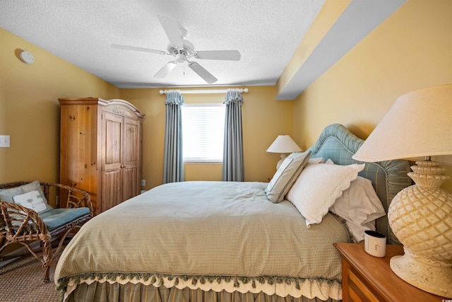 bedroom with ceiling fan and a textured ceiling