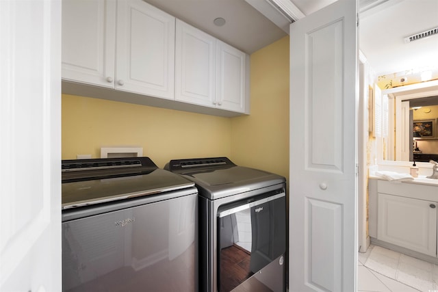 laundry area with cabinets, washer and clothes dryer, washer hookup, sink, and light tile floors