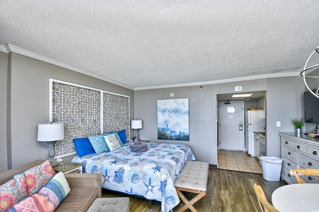 bedroom with a textured ceiling, white refrigerator, ornamental molding, and dark hardwood / wood-style floors