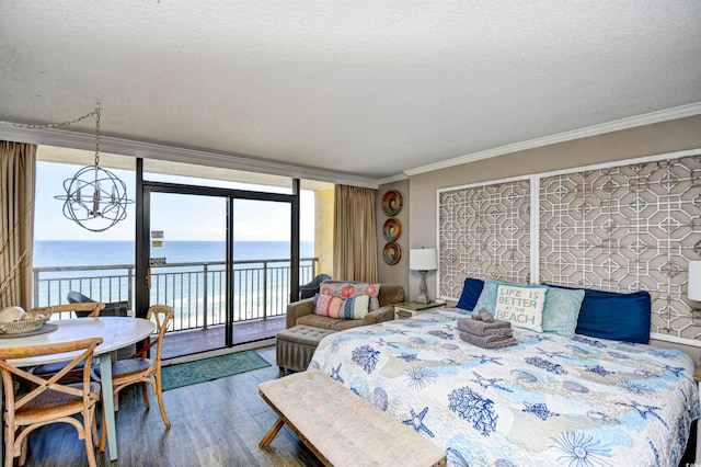 bedroom with access to outside, wood-type flooring, a textured ceiling, a chandelier, and a water view