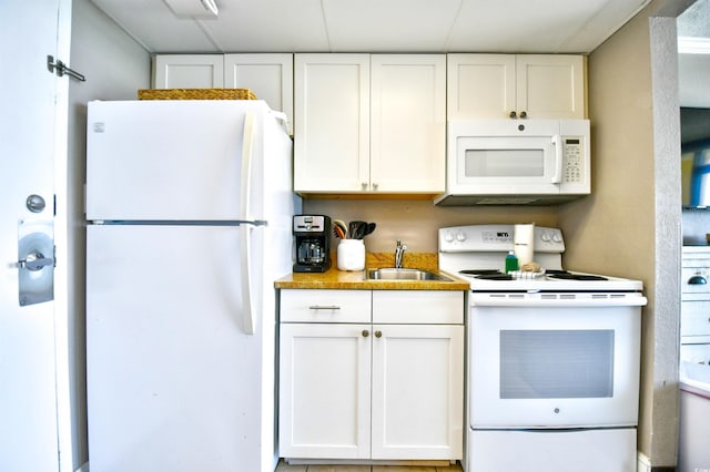 kitchen with white cabinetry, sink, and white appliances