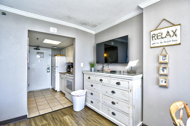 kitchen featuring crown molding, white appliances, a textured ceiling, and hardwood / wood-style flooring