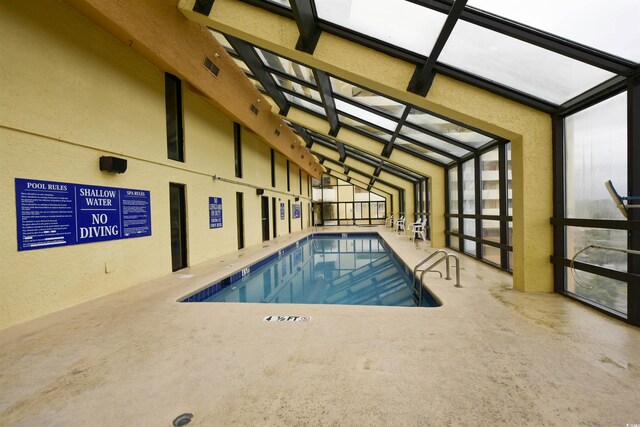 view of swimming pool featuring a patio area and a lanai