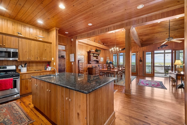 kitchen with wooden walls, appliances with stainless steel finishes, wooden ceiling, and hardwood / wood-style flooring