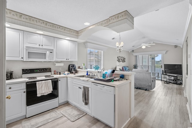 kitchen featuring kitchen peninsula, lofted ceiling, decorative light fixtures, white appliances, and white cabinets