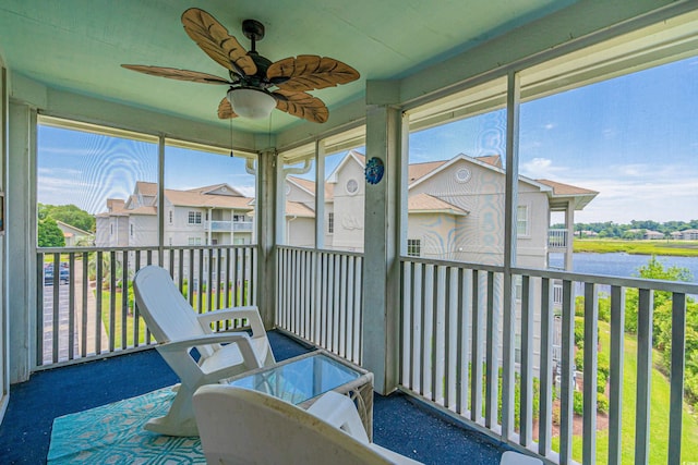 sunroom / solarium featuring ceiling fan, a healthy amount of sunlight, and a water view