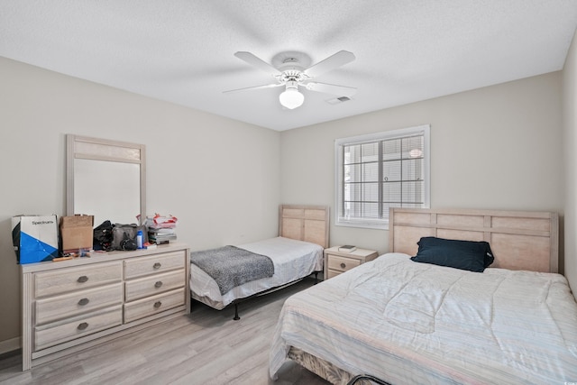 bedroom featuring a textured ceiling, light hardwood / wood-style flooring, and ceiling fan