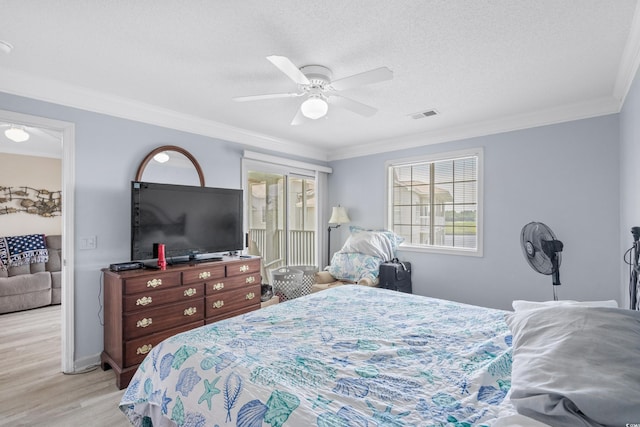 bedroom featuring ceiling fan, crown molding, a textured ceiling, and light wood-type flooring