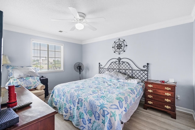 bedroom with ceiling fan, light wood-type flooring, a textured ceiling, and ornamental molding