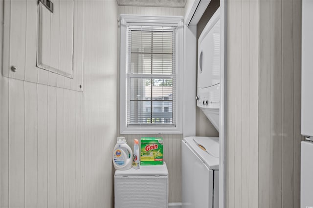 clothes washing area with stacked washer / dryer