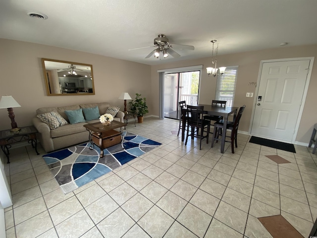 living room featuring ceiling fan with notable chandelier and light tile patterned floors