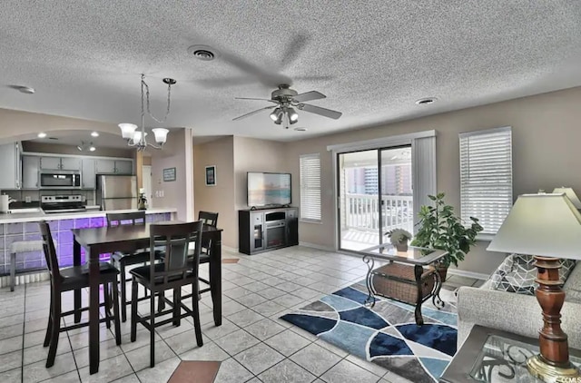 tiled living room featuring ceiling fan with notable chandelier