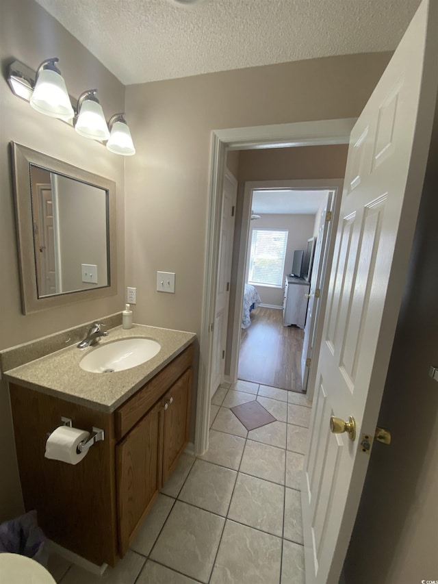 bathroom featuring tile patterned flooring, vanity, and a textured ceiling