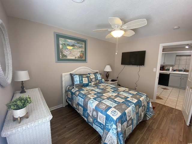 bedroom with sink, ensuite bathroom, ceiling fan, and dark hardwood / wood-style floors