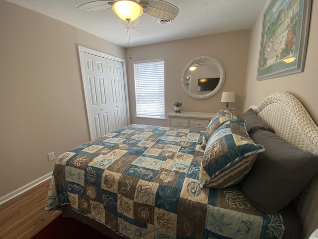 bedroom featuring a textured ceiling, hardwood / wood-style flooring, a closet, and ceiling fan