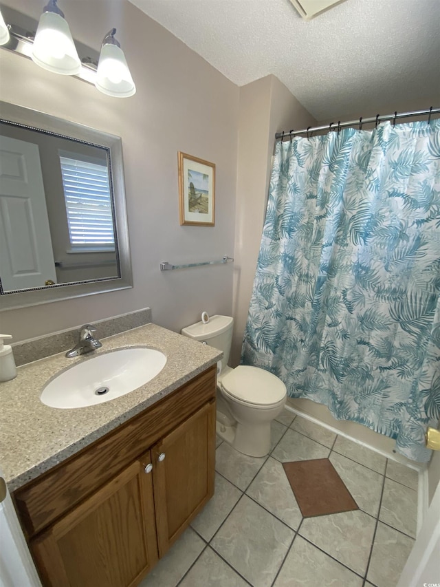 bathroom with tile patterned floors, vanity, a textured ceiling, and toilet