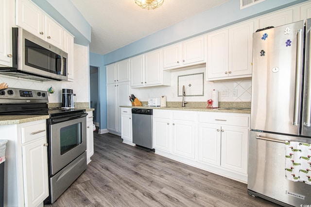 5800 N Ocean Blvd Unit 705, North Myrtle Beach, SC 29582 - kitchen featuring appliances with stainless steel finishes, backsplash, and white cabinets