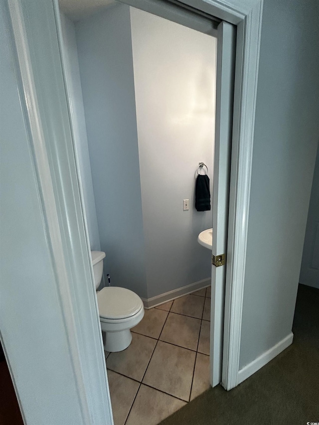 bathroom featuring toilet, baseboards, and tile patterned floors