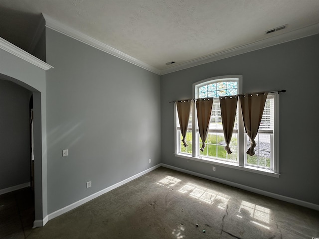 spare room featuring ornamental molding, arched walkways, a healthy amount of sunlight, and visible vents