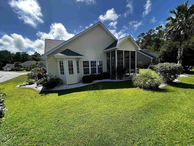 rear view of house with a lawn and a sunroom